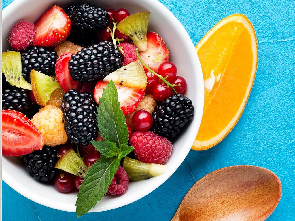 Un bol con frutas ricas en antioxidantes como arándanos, fresas y rodajas de naranja Un bol con frutas ricas en antioxidantes como arándanos, fresas y rodajas de naranja